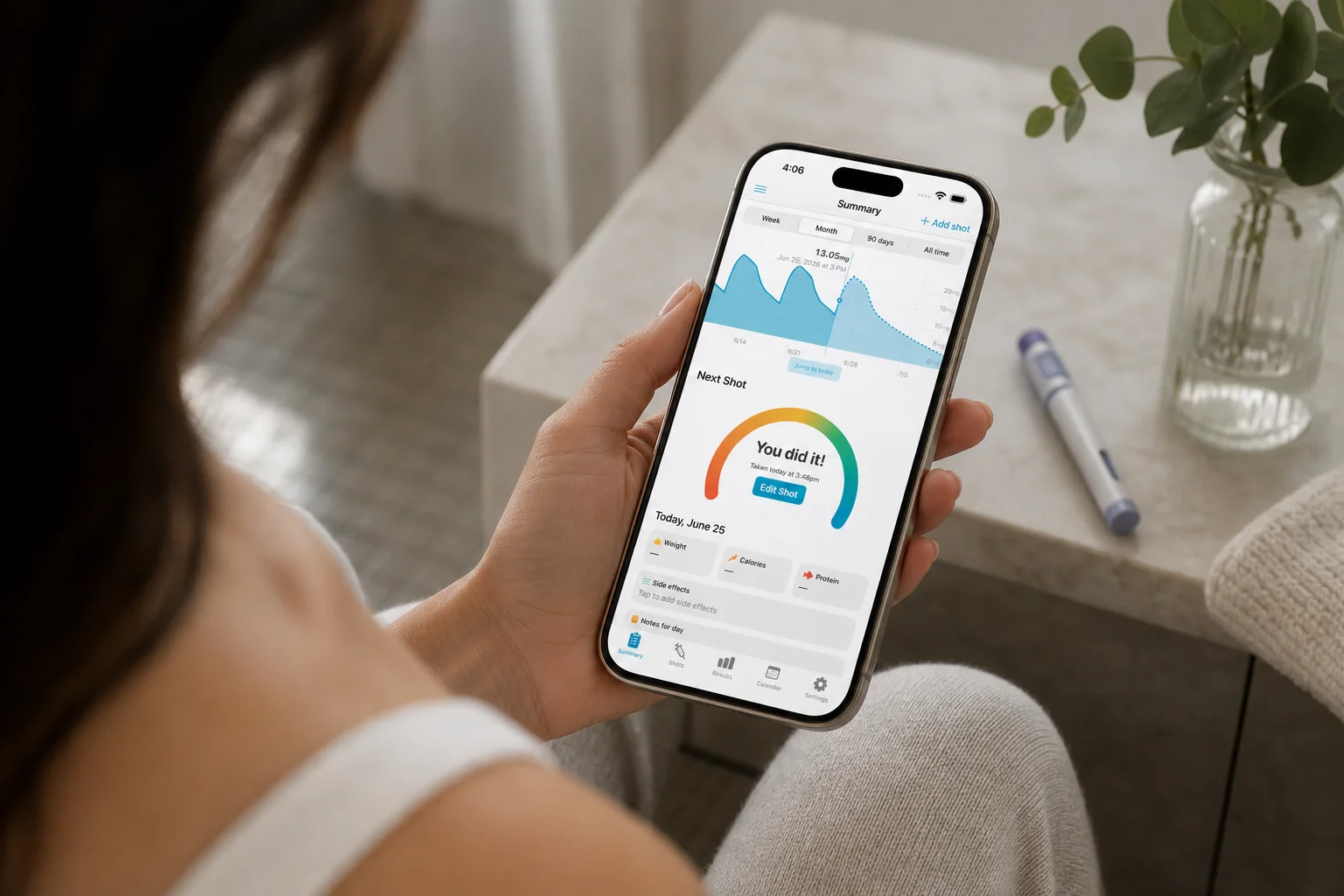 Woman reviewing a menstrual cycle calendar on her phone with a GLP-1 injection pen nearby