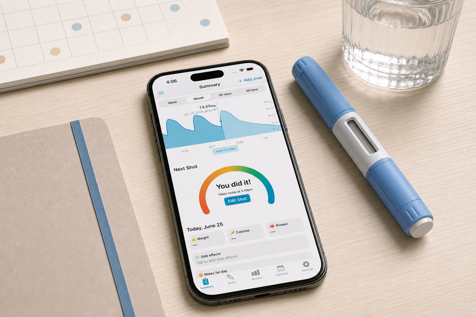 Shotsy app on a phone beside a calendar, journal, water, and a GLP-1 injection pen