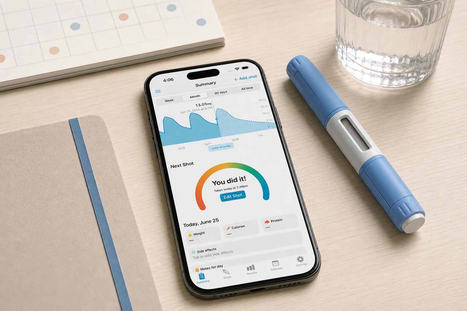Shotsy app on a phone beside a calendar, journal, water, and a GLP-1 injection pen