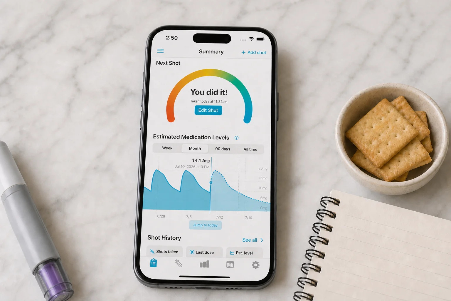 Shotsy app on a phone beside ginger tea, crackers, water, a symptom notebook, and a GLP‑1 injection pen