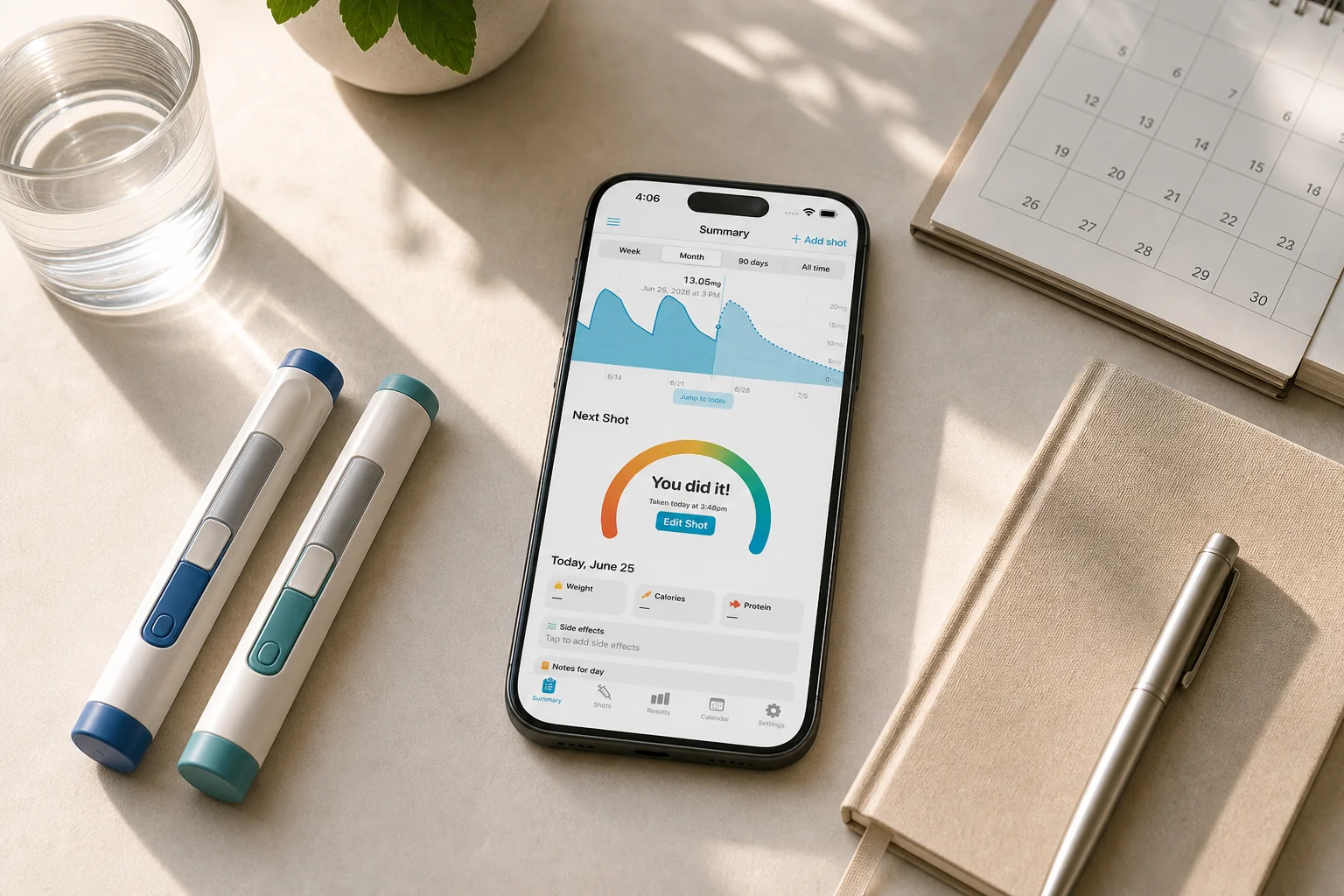 Shotsy app on a phone beside two GLP-1 injection pens, calendar, notebook, and water