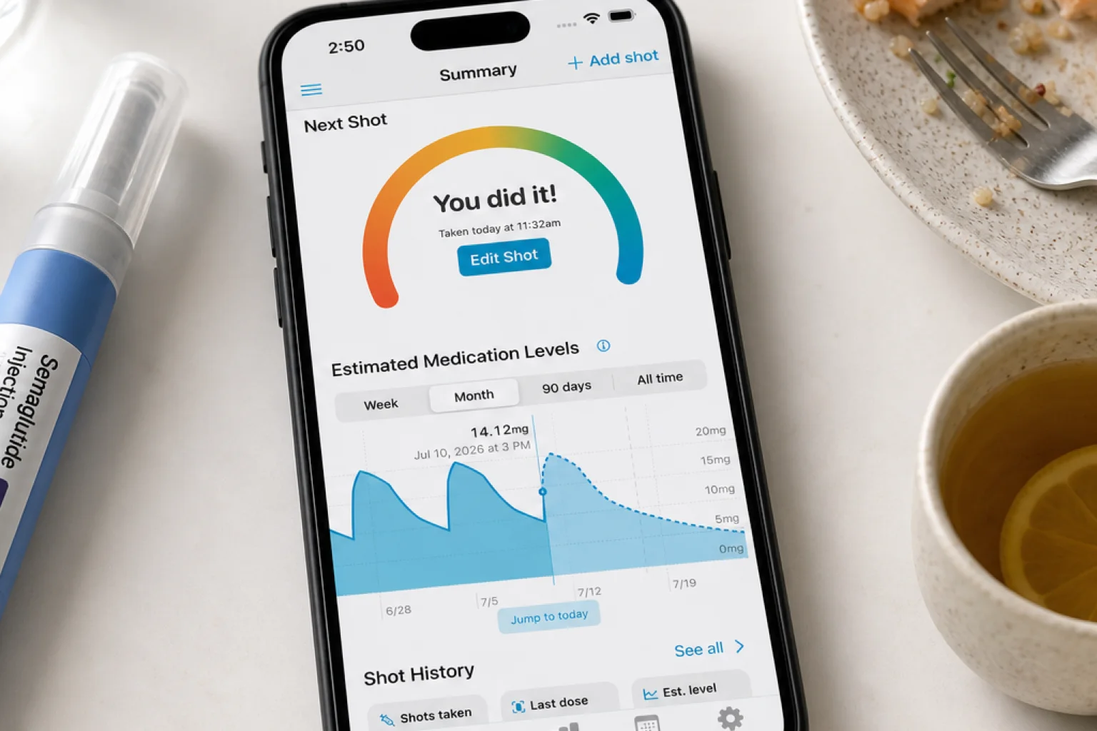 Shotsy app on a phone beside a small meal, ginger tea, water, meal journal, and GLP‑1 injection pen