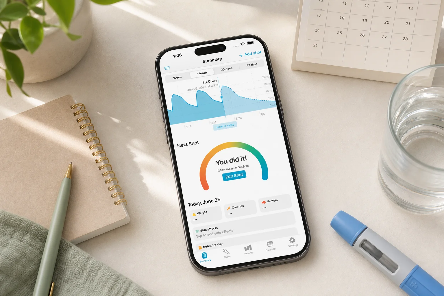 Shotsy app on a phone beside a calendar, journal, water, and GLP-1 injection pen